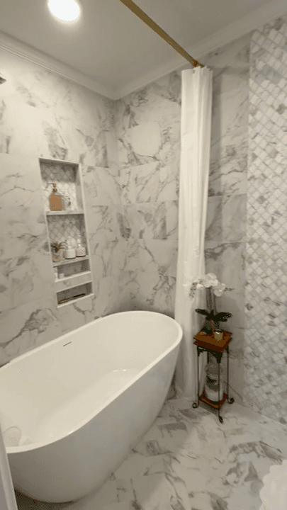 Vertical video clip showing a bathroom suite remodel with a freestanding tub and tile details.