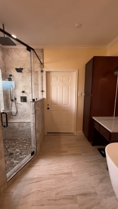 Vertical video clip showing a finished walk-in shower with glass, tile, and bathroom finishes.