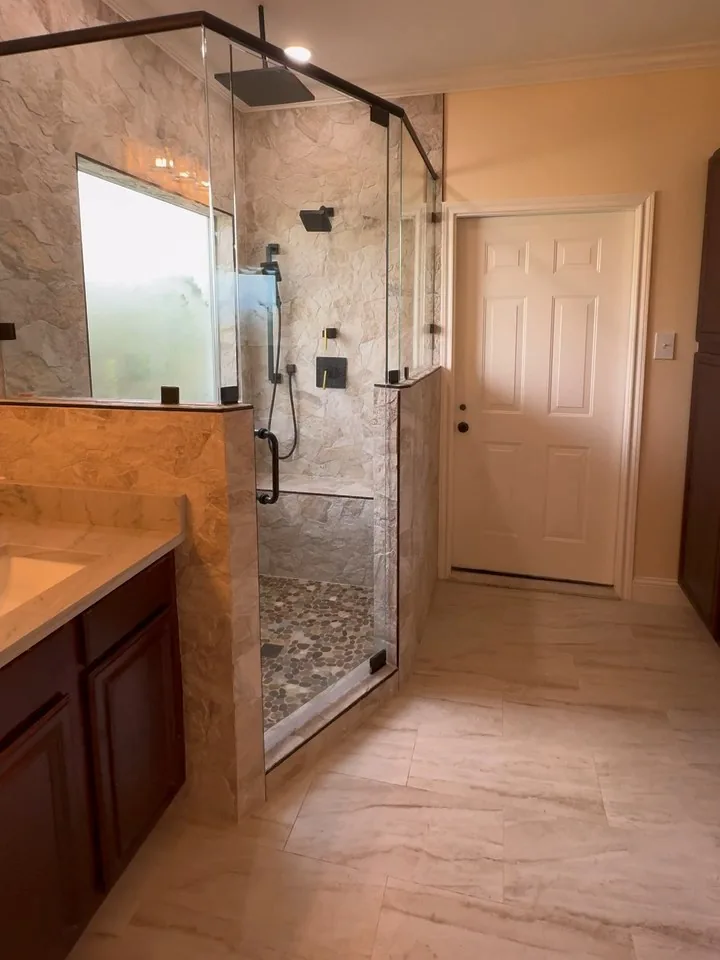 Glass shower, tiled pony wall, vanity, and bathroom floor in Pioneer's Tyler bathroom layout remodel