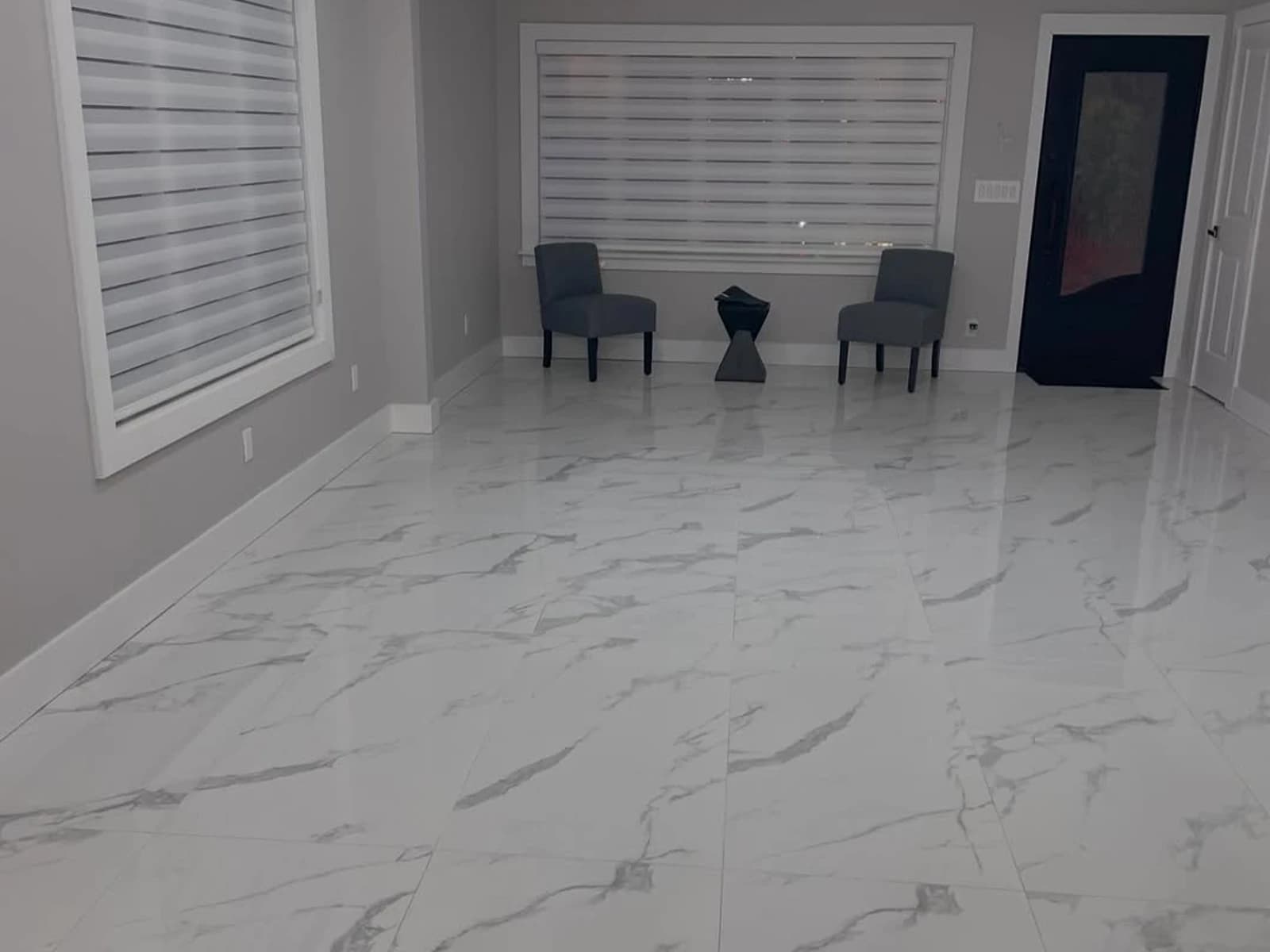 Glossy marble-look tile flooring installation with gray walls, recessed lights, and window shutters