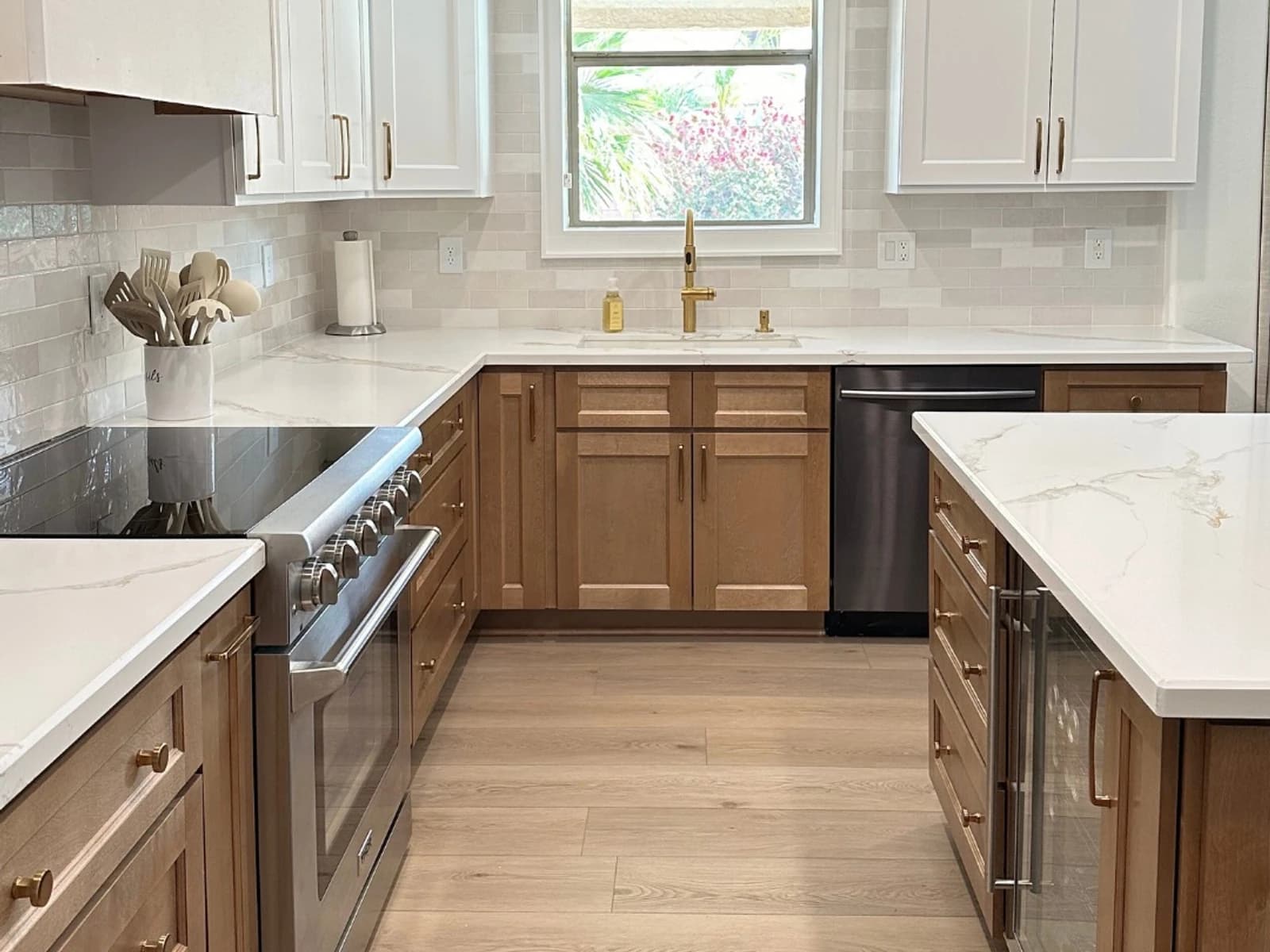Finished kitchen with wood lower cabinets, white upper cabinets, marble-look counters, tile backsplash, island, and plank flooring
