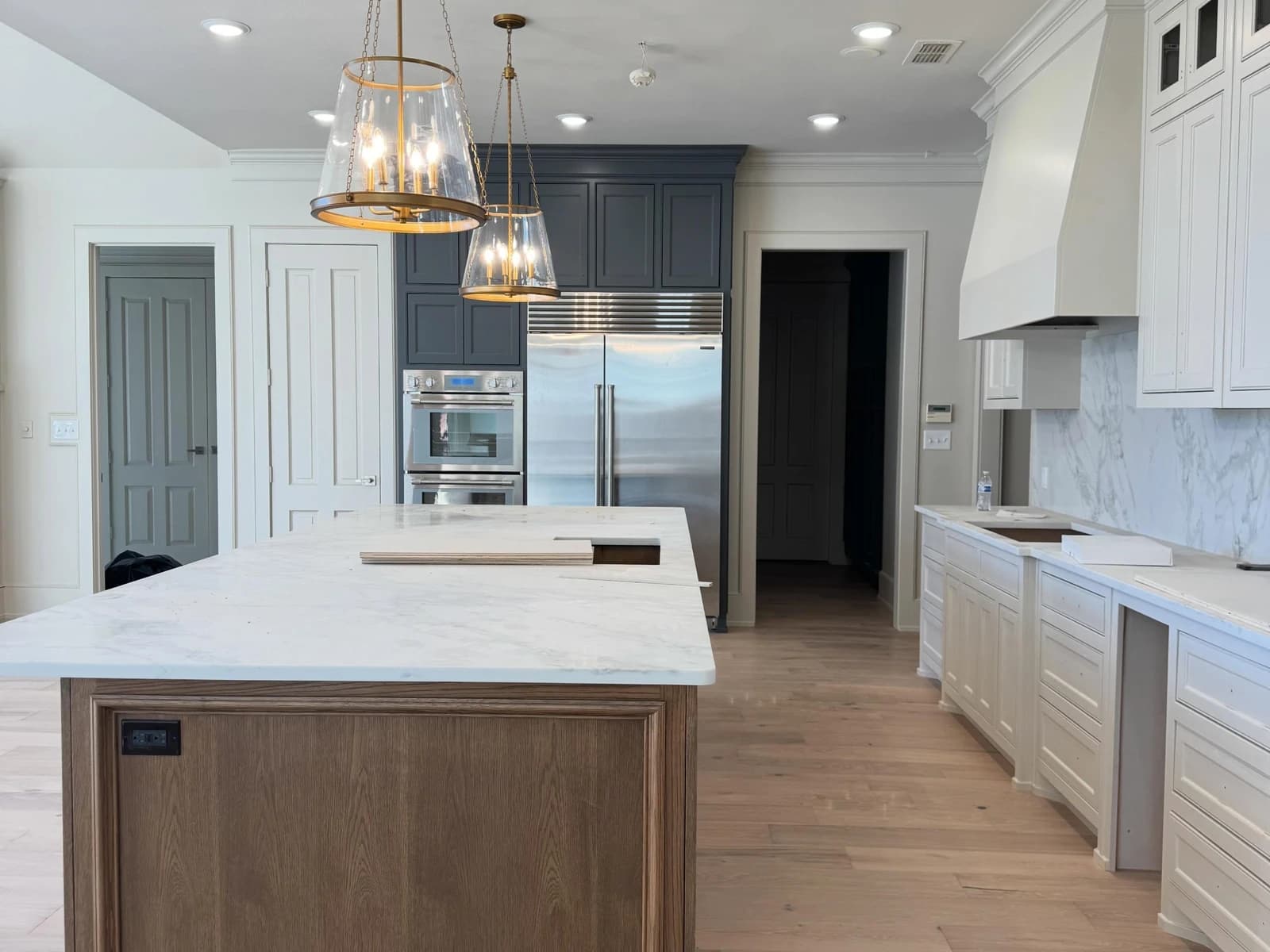 Kitchen island remodel with glass pendant lights, tall cabinets, skylight, recessed lighting, and wood-look flooring