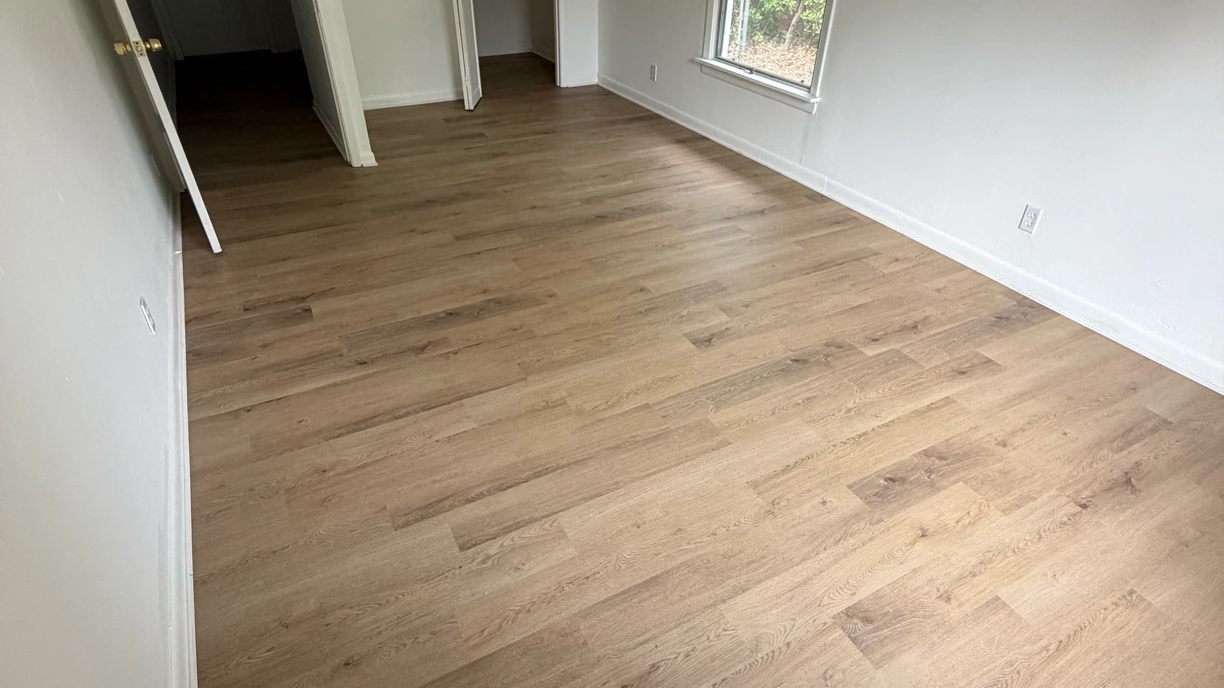 Finished wood-look plank flooring across an empty room in Longview TX