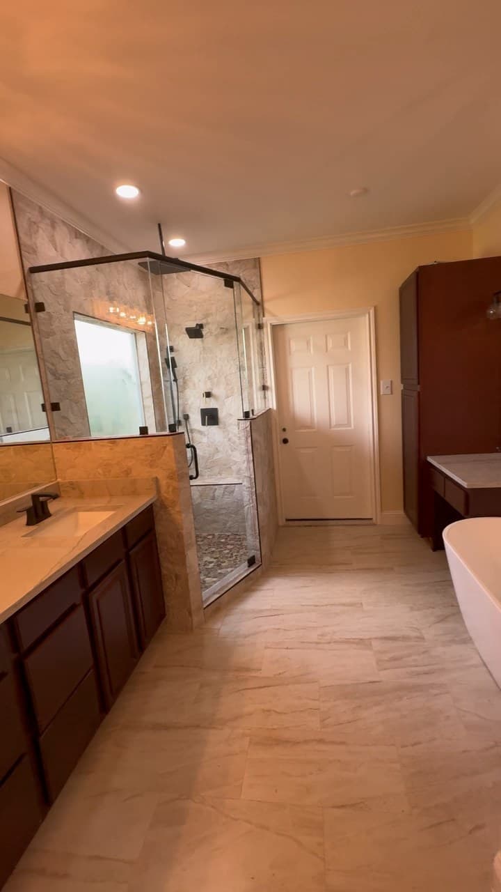 Finished Tyler bathroom remodel with vanity, countertop, glass shower, tile floor, recessed lighting, and storage cabinetry